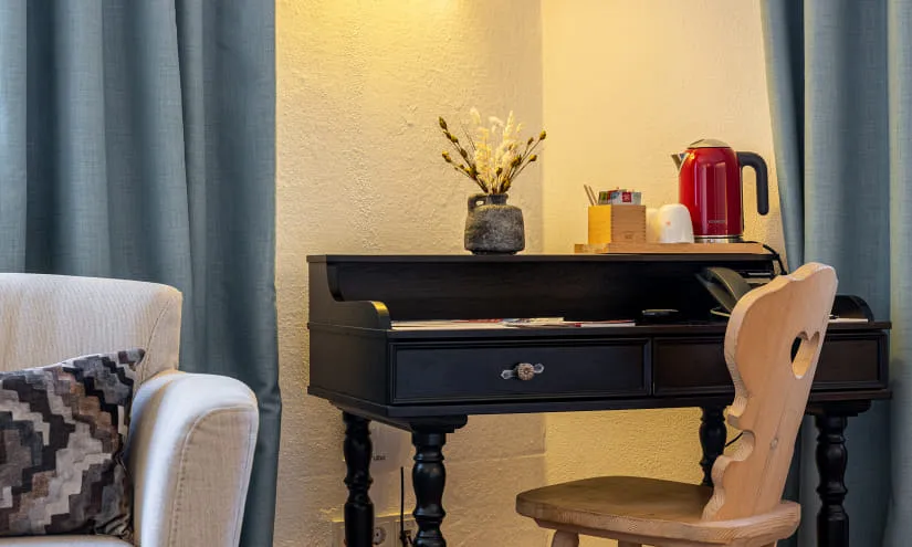 Schreibtisch mit Dekoration und Stuhl im Wohnzimmer.