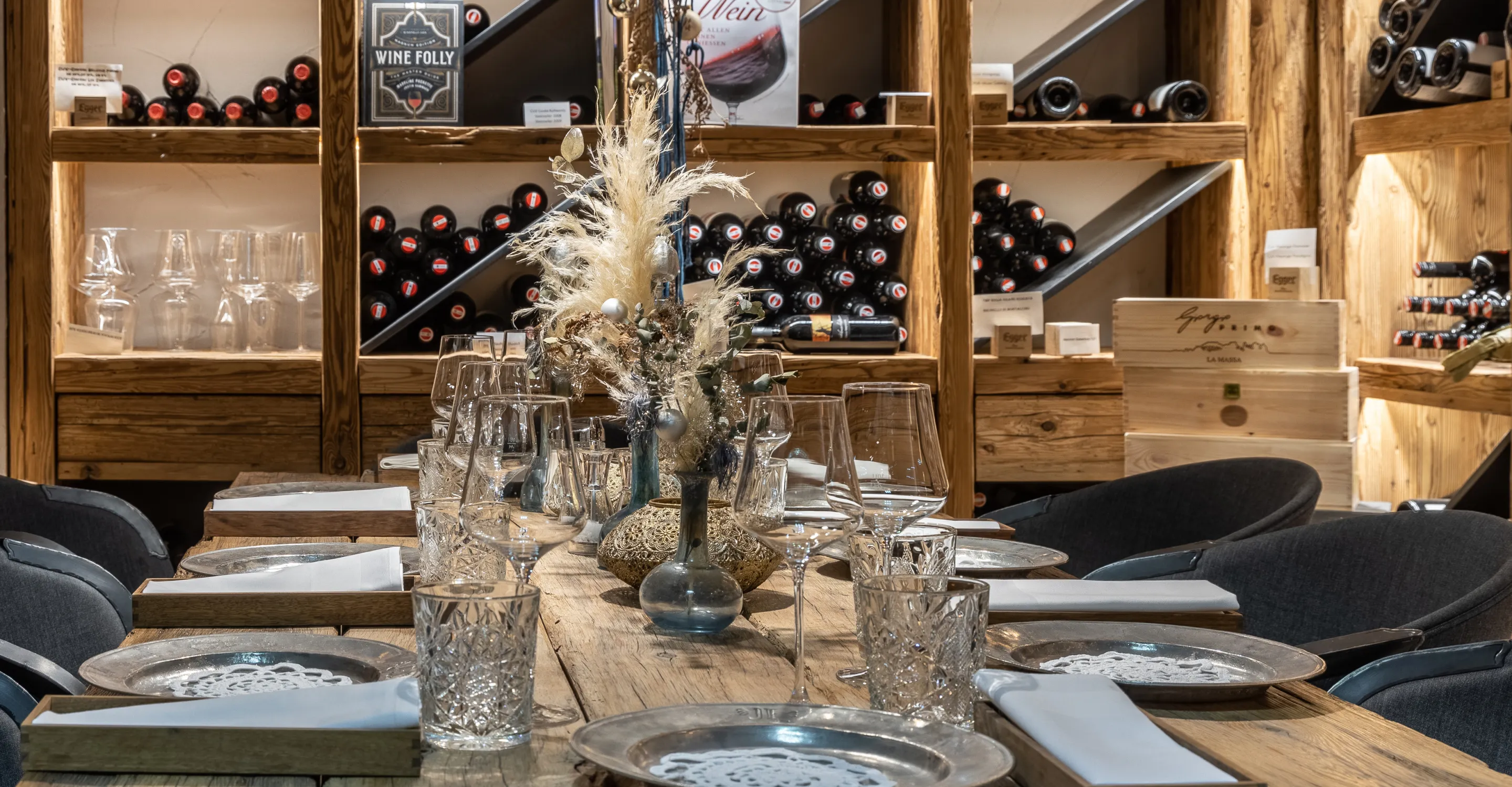 Eleganter Tisch im Wirtshaus mit Geschirr und Weinfächern im Hintergrund