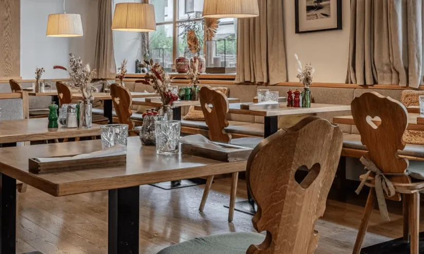 Gemütliche Restaurantansicht mit Holztischen und stimmungsvoller Beleuchtung.