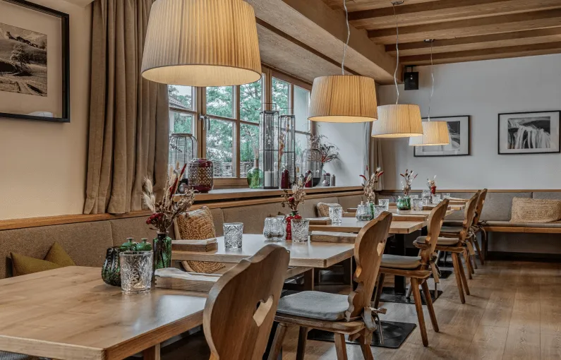 Innenansicht eines Restaurants mit Holzmöbeln und Pendelleuchten
