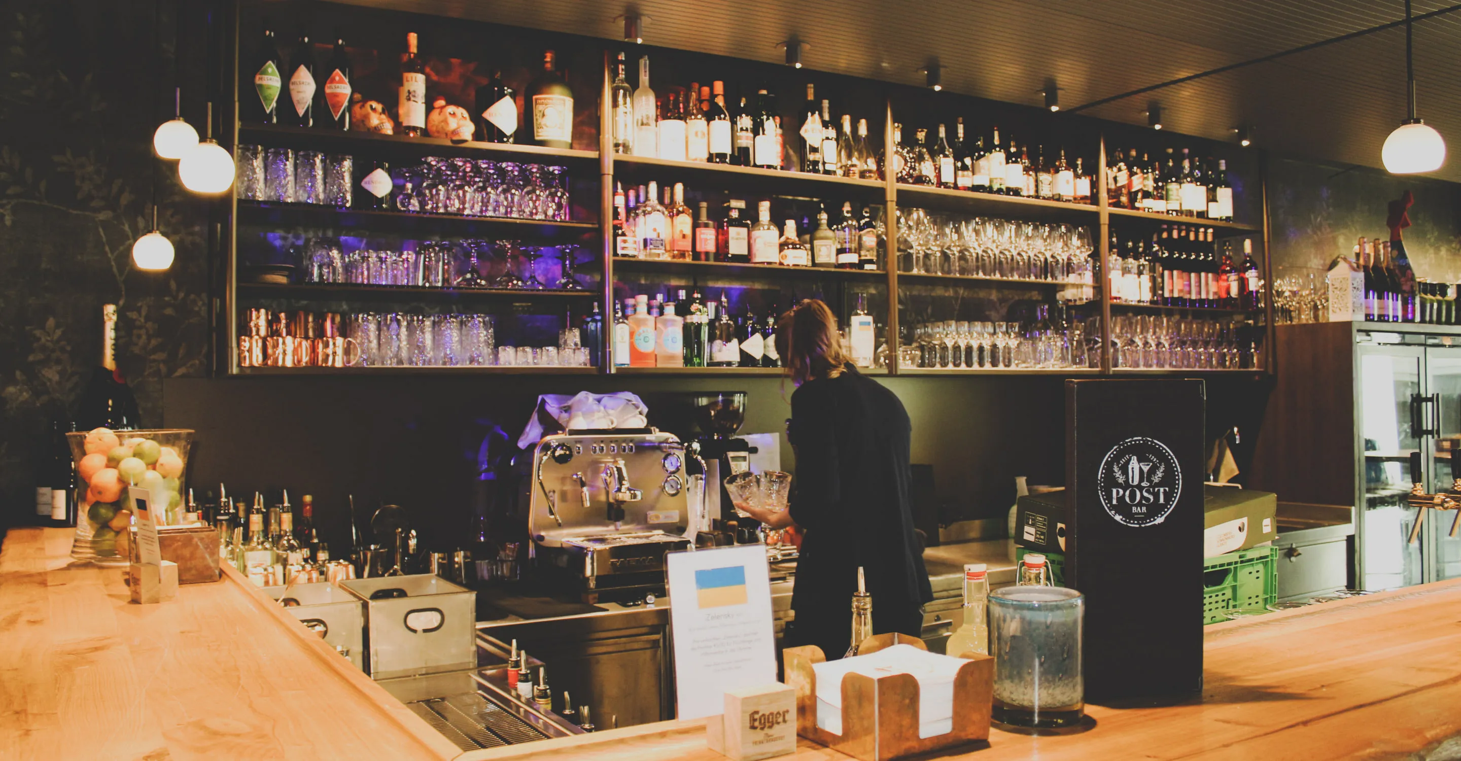 Moderne Bar mit Getränken und Gläsern auf Regalen