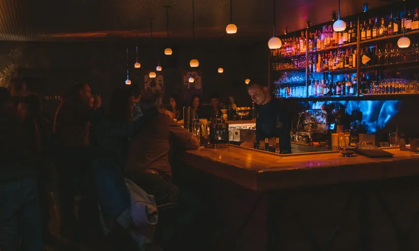 Ein stilvoller Barbereich mit einem Bartender und vielen Gästen.
