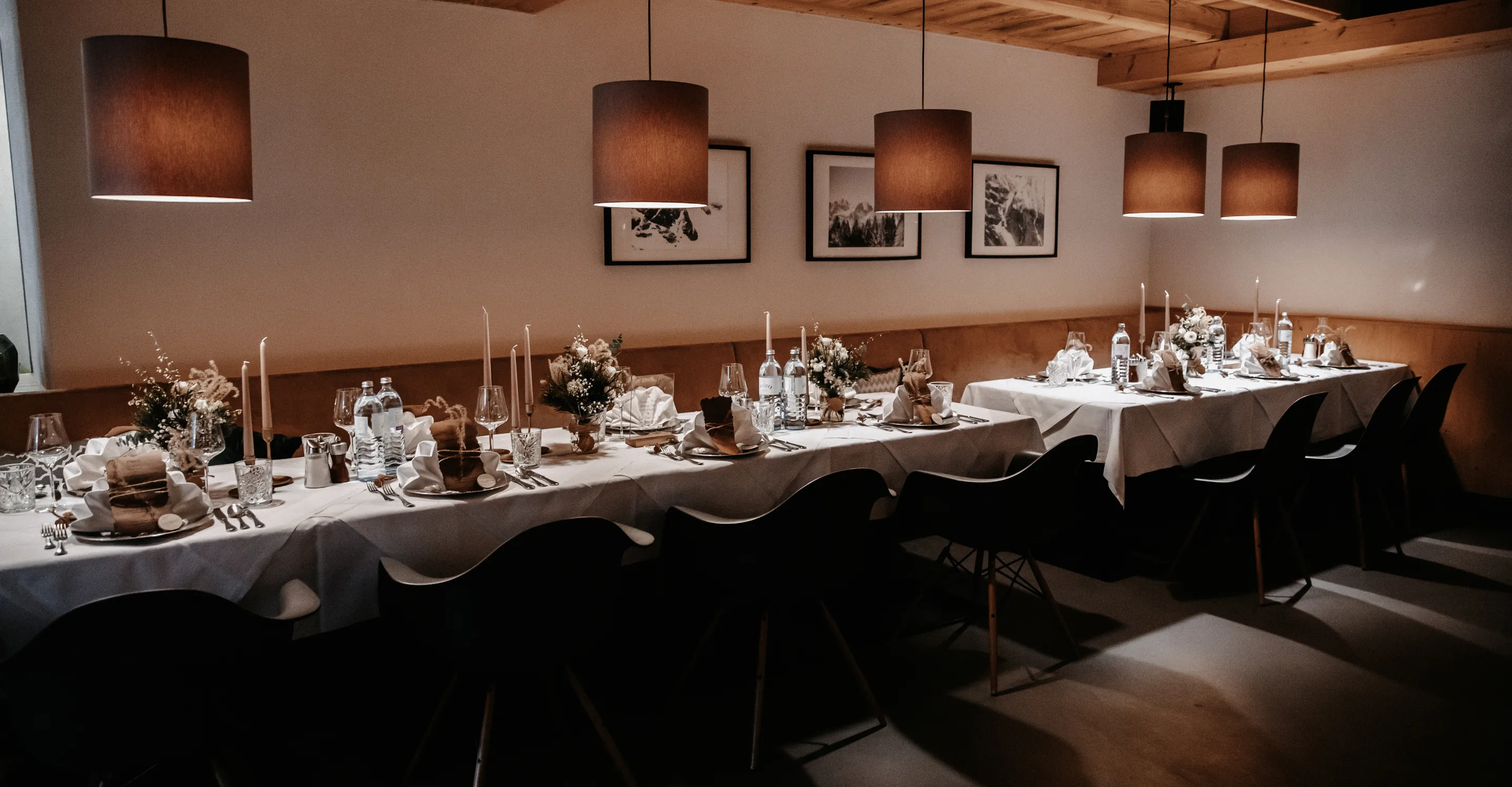 elegant dekorierter Speisesaal mit Tischen, Stühlen und Pendelleuchten