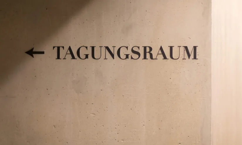 Wand mit dem Schriftzug 'TAGUNGSRAUM' und einem Pfeil nach links