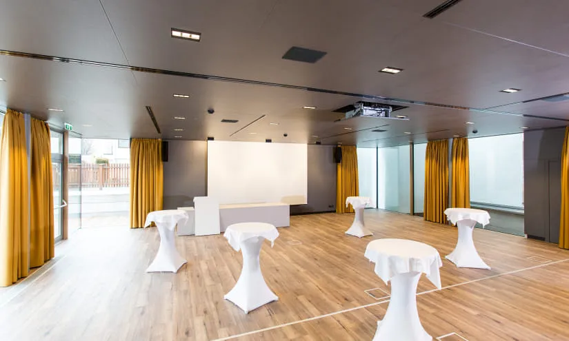 Modernes Tagungszimmer mit Stehtischen und großen Fenstern