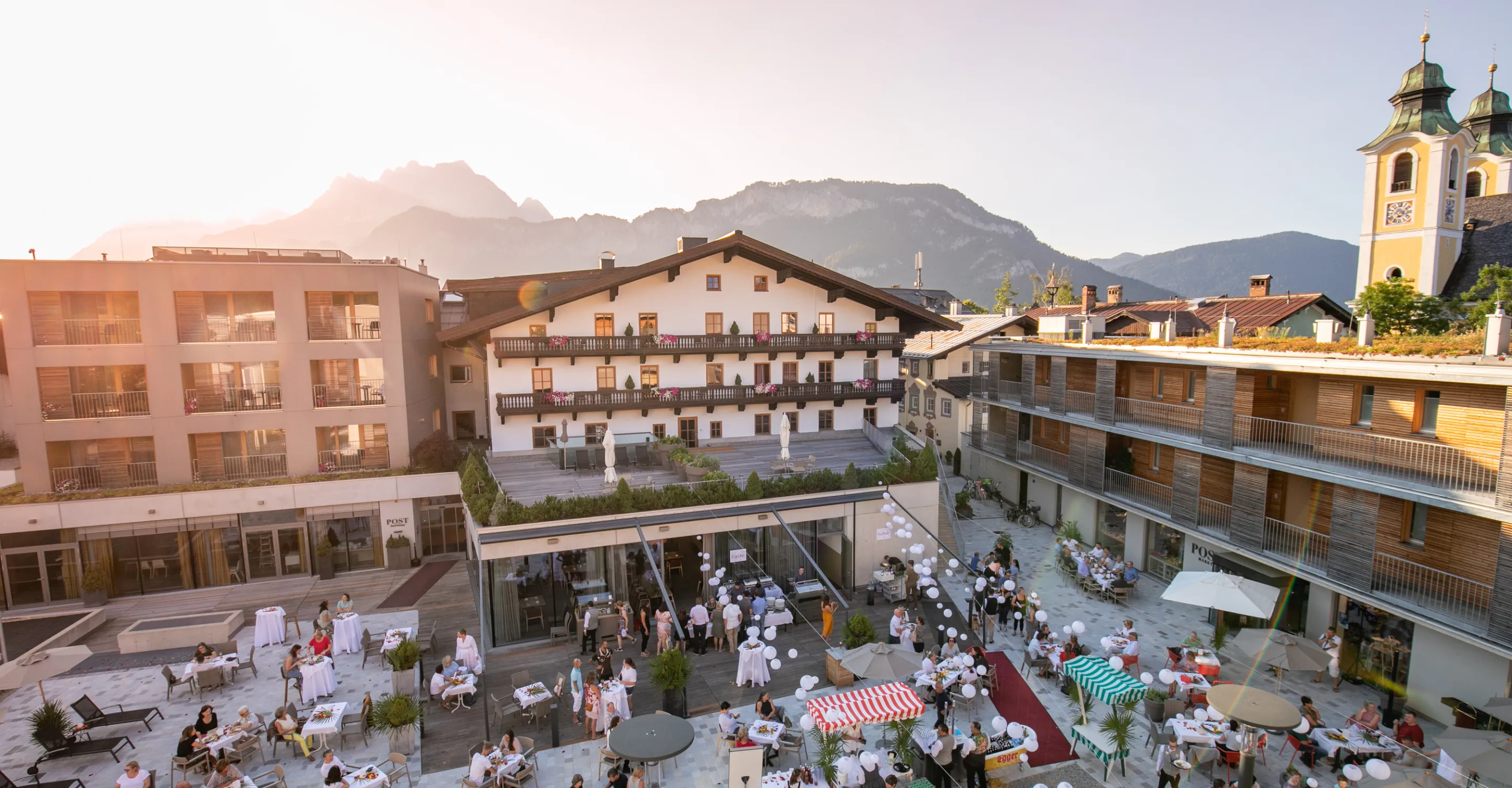 Lebhafte Sommernacht mit festlich gedeckten Tischen und Bergkulisse